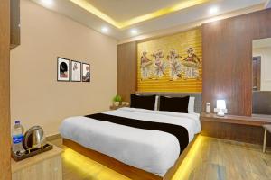 a bedroom with a large bed in a room at Townhouse Oak City Centre Dhanbad Formerly Hotel Kuber Inn in Dhanbād