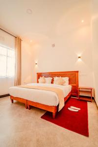 a bedroom with a large bed and a red rug at Maasai Villa in Arusha