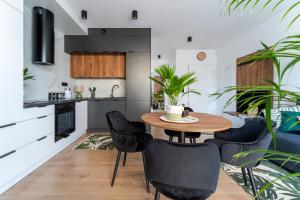 a kitchen with a wooden table and black chairs at HappyDeer - Ekskluzywny apartament z widokiem na góry in Jelenia Góra