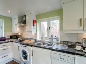 a kitchen with a sink and a washing machine at 1 Bed in Fenny Bentley 80376 in Fenny Bentley