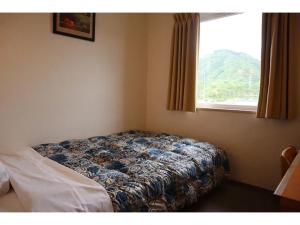a bed in a room with a window at Maniwa City Hotel Sunrise - Vacation STAY 98578v in Maniwa