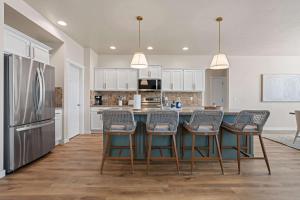 a kitchen with a table with chairs and a refrigerator at 4BR Retreat With Hot Tub Greenbelt Pond Sleeps 12 in Nampa