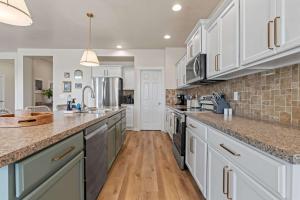 a large kitchen with white cabinets and wooden floors at 4BR Retreat With Hot Tub Greenbelt Pond Sleeps 12 in Nampa +33 photos