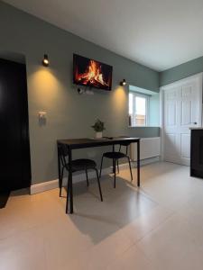a dining room with a table with a fire on the wall at Corporate Nest Sallins in Balnacart