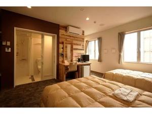 a bedroom with two beds and a desk and a bathroom at Maniwa City Hotel Sunrise - Vacation STAY 98584v in Maniwa