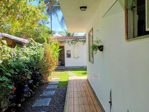 a walkway leading to a white house with plants at Cantinho da Paz in Serra Grande