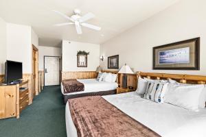 a hotel room with two beds and a flat screen tv at Majestic Lake Views King Suite, 2 Queen Beds and Heated Pools in Two Harbors