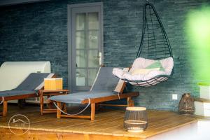 a porch with two chairs and a hanging hammock at Apartment & Spa L'Oasis Urbaine in Chambéry