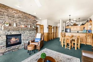 a living room with a fireplace and a stone wall at Majestic Lake Views King Suite, 2 Queen Beds and Heated Pools in Two Harbors