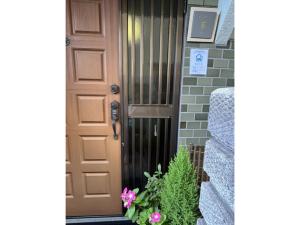 a brown door with a plant next to it at Guest House Aoi - Vacation STAY 20031 in Mitsugarasuchō +5 photos