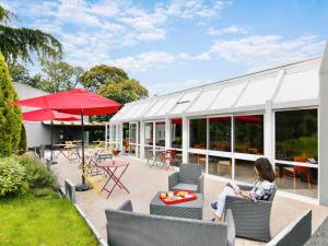 a woman sitting in a chair in front of a building at ibis Quimper in Quimper