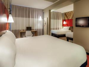 une chambre d'hôtel avec un lit blanc et une télévision dans l'établissement ibis Quimper, à Quimper 68 autres photos