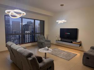 ein Wohnzimmer mit zwei Stühlen und einem Flachbildfernseher in der Unterkunft Shams Wa Bahar Vacation Homes Rental in Dubai