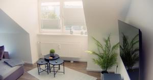 a living room with a couch and a table and two plants at 3 Zimmer Apartment zentral und ruhig - Nähe Autostadt, Parkplatz und WLAN - CityStay Wolfsburg - Beetle in Wolfsburg