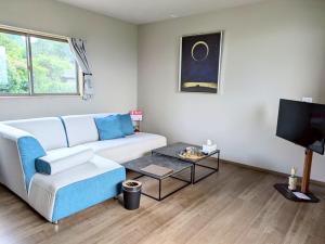 a living room with a couch and a tv at Minamiaso Sauna 5GAKU - Vacation STAY 24183v in Minami Aso