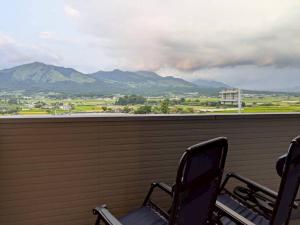 two chairs on a balcony with a view of mountains at Minamiaso Sauna 5GAKU - Vacation STAY 23343v in Minami Aso +7 photos