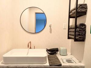 a bathroom with a white sink and a mirror at Minamiaso Sauna 5GAKU - Vacation STAY 23343v in Minami Aso