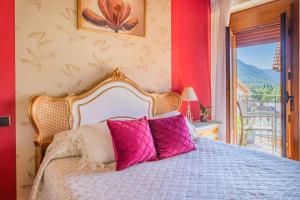 a bedroom with a bed with pink pillows at Casa Maza Apartamentos in Biescas