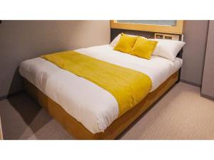une chambre avec un grand lit avec des oreillers jaunes dans l'établissement THE GALA HOTEL UMEDA - Vacation STAY 24213v, à Osaka