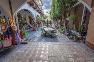 an alley with a table and chairs and plants at Las Mariposas Hotel & Studios in Oaxaca City