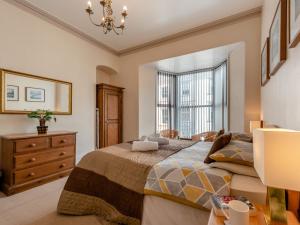 a bedroom with a bed and a dresser and a window at 6 Bed in Tenby FB220 in Tenby