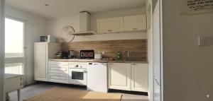 una cucina con mobili bianchi e un frigorifero bianco di Apartement entier - 8 personnes - Angoulême ad Angoulême