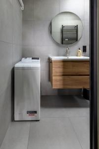 a bathroom with a washer and a sink and a mirror at De Aanbouw van Foonloos - luxe studio vlakbij Utrecht in Houten
