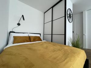 a bedroom with a bed and a clock on the wall at Studija Tauragė pirmas aukštas in Tauragė
