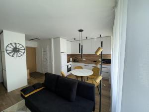 a living room with a couch and a table at Studija Tauragė pirmas aukštas in Tauragė +3 photos