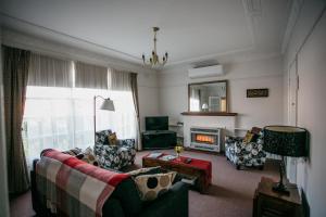 a living room with a couch and a fireplace at Goldies on Piper Kyneton in Kyneton