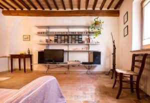 een woonkamer met een televisie en een bureau met een televisie bij Casa Burelli in Montalcino