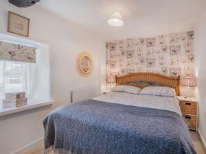 a bedroom with a large bed with a blue blanket at 3 Bed in Baycliff SZ130 in Baycliff