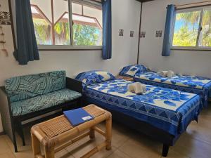 a room with two beds and a couch and a chair at Tikehau Paradise in Tikehau Airport