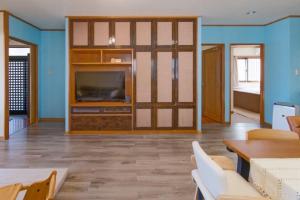 un salon avec une télévision et un canapé dans l'établissement Ishigaki - House - Vacation STAY 30825v, à Ishigaki