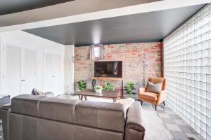 ein Wohnzimmer mit einer Couch und einer Ziegelwand in der Unterkunft King Bed Free Parking Brick Carriage House in Alexandria
