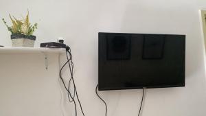 a flat screen tv hanging on a wall at Pousadinha Mel - Centro de Convenções in Salvador