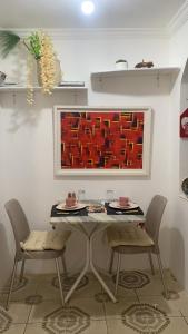 a table and chairs in a room with a painting at Pousadinha Mel in Salvador