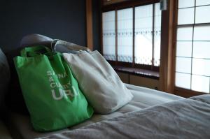 京丹後市にあるSAUNA&CURRY URI Kyotango - Vacation STAY 31558vのベッドの上に置かれた緑と白の買い物袋2つ