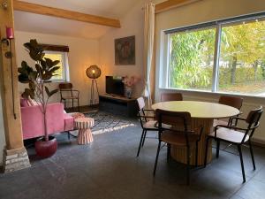 a living room with a table and a pink couch at Groepsverblijf Het Bonte Paard in Dwingeloo