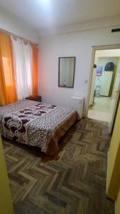 马德普拉塔Dpto céntrico的一间带床的酒店房间和一条带椅子的走廊