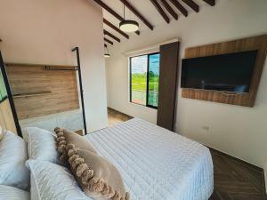 a bedroom with a bed and a flat screen tv at Antara Resort in Alcalá