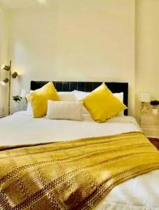 a bedroom with a large bed with yellow pillows at Downtown Nola 2bd 2bth Condo in New Orleans +13 photos