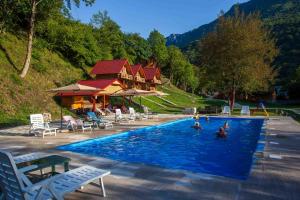 a swimming pool with a house in the background at Rafting Center "TARA-RAFT" in Bastasi