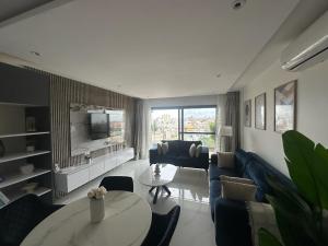 a living room with a couch and a table at Appartement spacieux, piscine, balcon, vue sur mer et salle de sport in Dakar