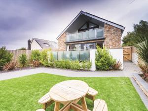 a garden with a wooden table and a house at 2 Bed in Westward Ho 45753 in Northam