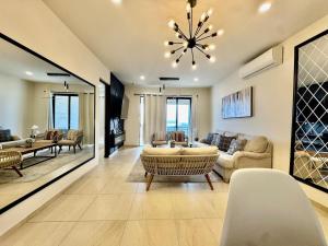 a living room with a chandelier and a table and chairs at Your escape in Cabo Comfortable and elegant apartment in Cabo San Lucas