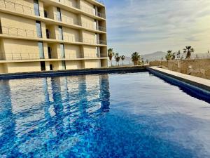a large swimming pool in front of a building at Your escape in Cabo Comfortable and elegant apartment in Cabo San Lucas
