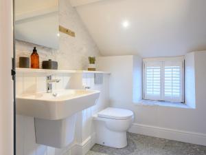 a white bathroom with a sink and a toilet at 3 Bed in Ogmore-by-Sea 86494 in Southerndown +16 photos