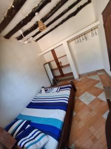 a bedroom with a bed with blue and white stripes at Masai 2 in Diani Beach