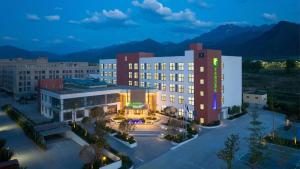 a rendering of a hotel with mountains in the background at Holiday Inn Express Xi'an Caotang Technology Park by IHG in Fengyukou
